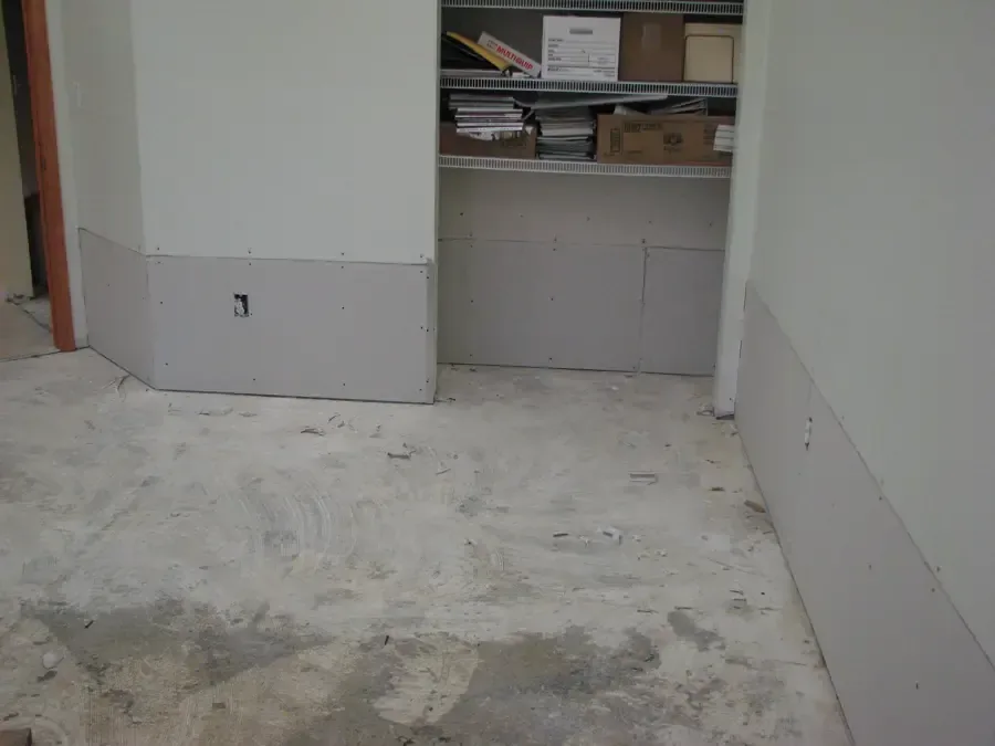 A room with opened lower wall finishes during a water damage dry-out