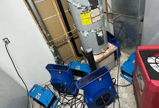 Blue drying machines positioned around a water heater in a utility space