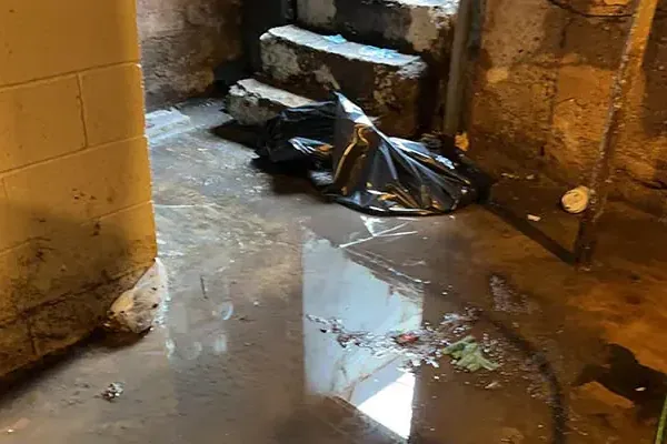 Floodwater covers a basement floor beside a short flight of stairs